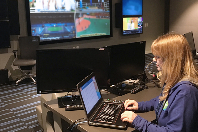 person at computer with monitors in background