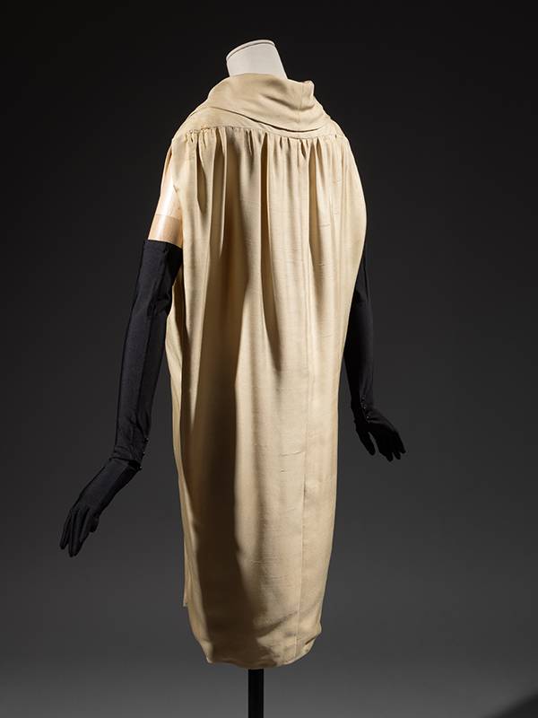 rear view of a cream-colored sack dress on a mannequin