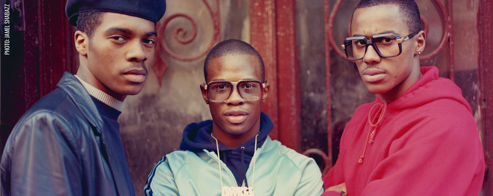 three young men wearing a leather jacket, a sports jacket, and a hoodie from left to right