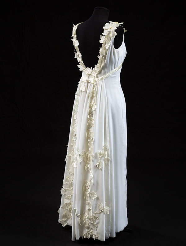 back view of white dress with fabric flowers on a mannequin